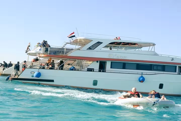 Hurghada Eden Island tour yacht with guests enjoying a banana boat ride on the Red Sea with lunch included