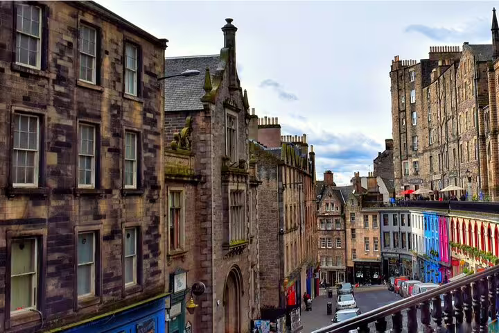 Victorian-era stone buildings and colorful shopfronts along Victoria Street in Edinburgh Old Town