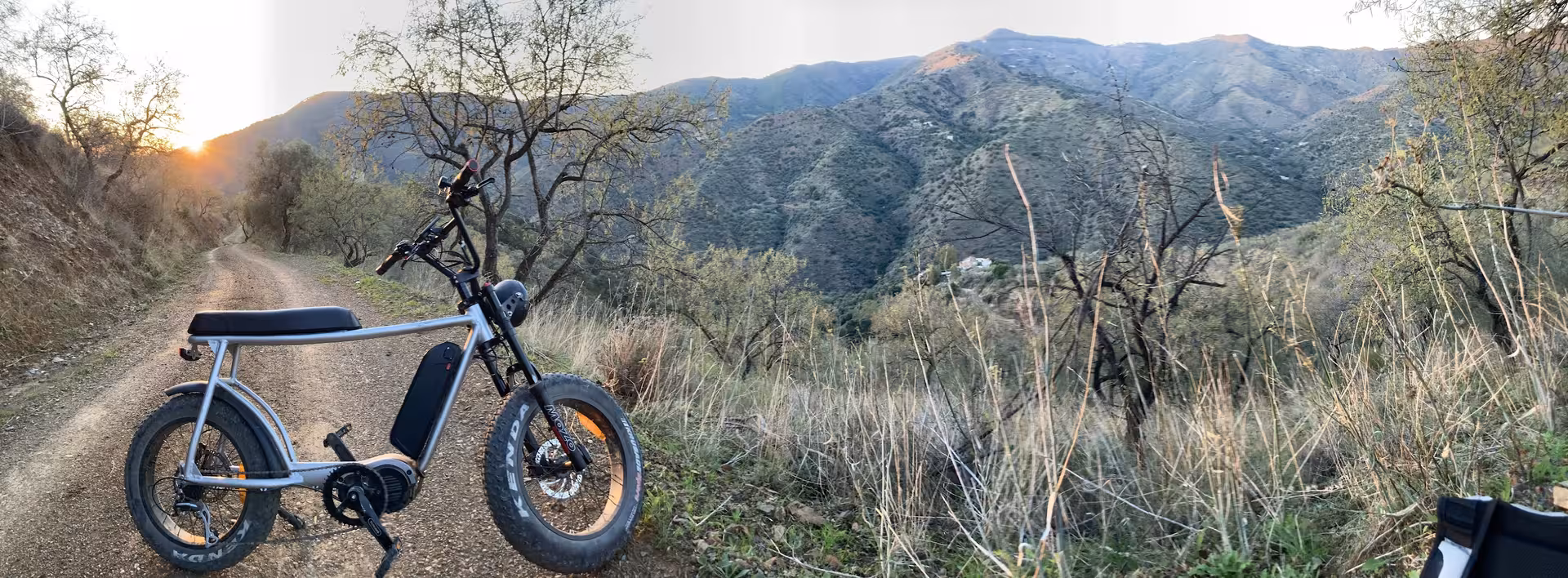 E-fat bike rental on mountain dirt trail at sunset, showcasing 4-hour ride for scenic trails and coastal views