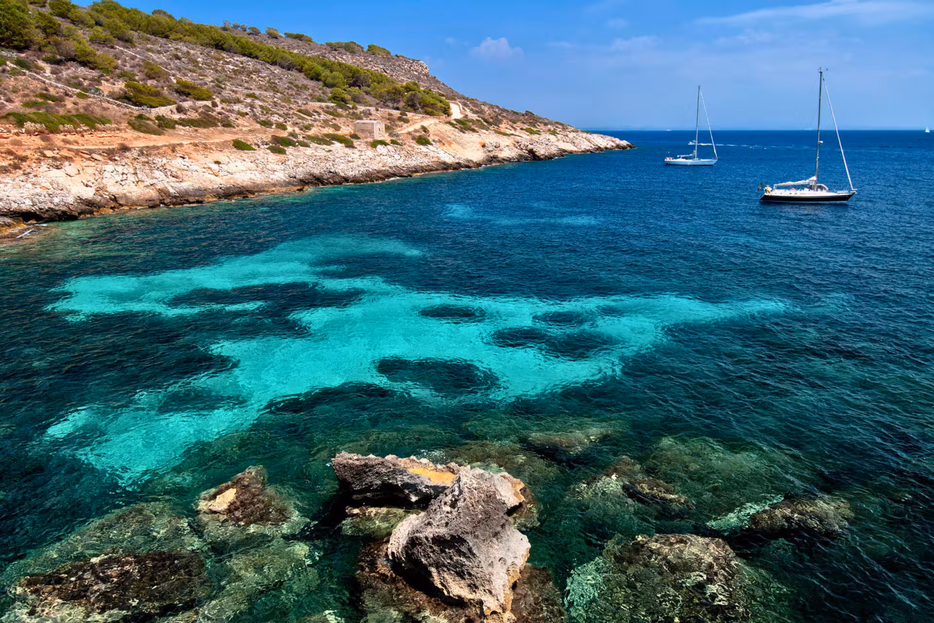 Crystal-clear Levanzo cove with sailboats, Egadi Islands private boat excursion from Trapani with lunch