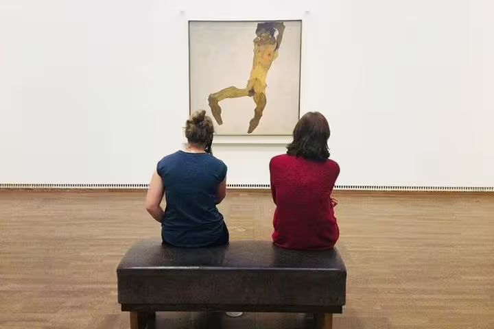 Visitors seated in front of Egon Schiele painting at Leopold Museum, enjoying private art historian-led tour.