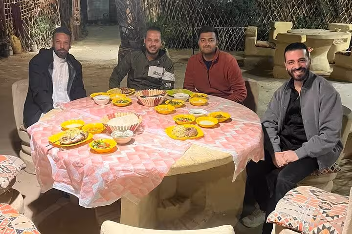 Local Egyptian dinner spread on a shared table with hosts, part of an eat like a local food and tea tour