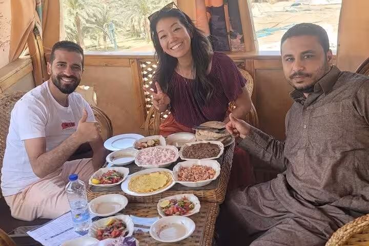 Travelers sharing traditional Egyptian mezze and tea in a local tent setting during a food tasting tour