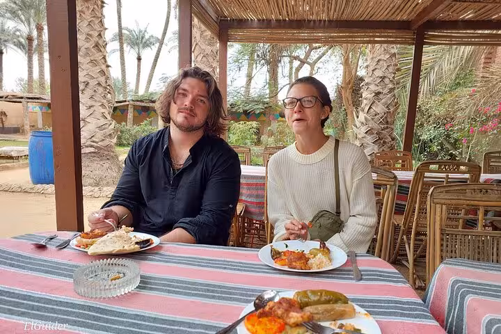 Tour guests enjoying traditional Egyptian lunch at a palm garden restaurant on Memphis and Saqqara private tour