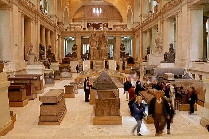 Egyptian Museum Cairo gallery with ancient statues and sarcophagi on full-day private Pyramids tour