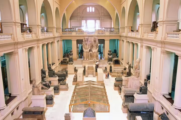 Egyptian Museum Cairo grand hall with statues and artifacts on a day tour from Alexandria with guide