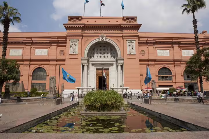 Egyptian Museum Cairo exterior on day tour from Alexandria, iconic pink facade with garden pond