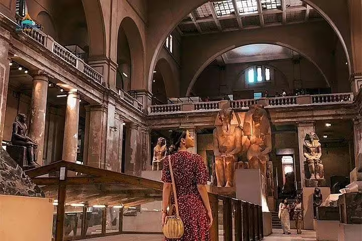 Visitor exploring the Egyptian Museum in Cairo with ancient statues, included in Alexandria to Cairo day trip tour