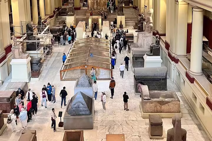 Egyptian Museum Cairo gallery with crowds and ancient sarcophagi on Giza and Cairo day tour from Sharm