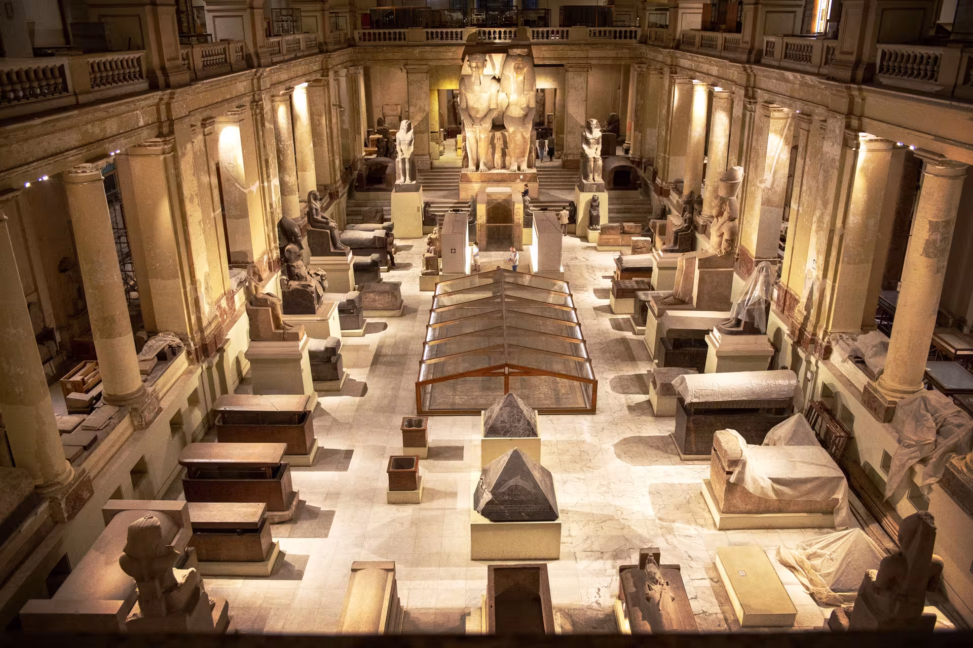 Grand hall of Cairo Egyptian Museum with towering statues and sarcophagi on a private guided tour
