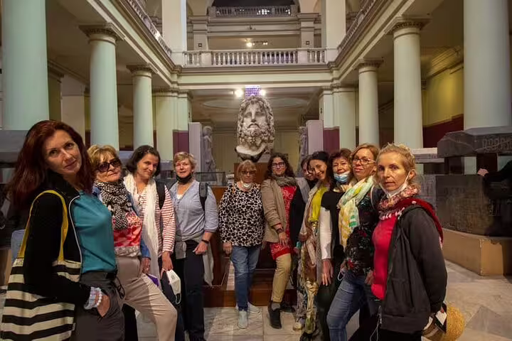 Tour group inside the Egyptian Museum Cairo near monumental statue, part of National Museum and Citadel tour