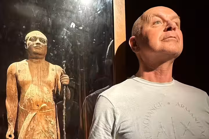 Visitor viewing ancient wooden Egyptian statue inside Cairo Egyptian Museum on a private guided tour