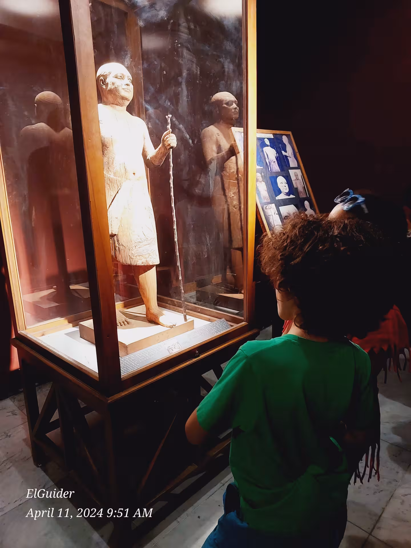 Visitor viewing an ancient Egyptian statue exhibit at the Egyptian Museum, Cairo on a private 4-day tour