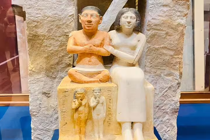 Ancient Egyptian seated couple statue at Cairo Museum, highlight on Giza Pyramids day tour from Hurghada
