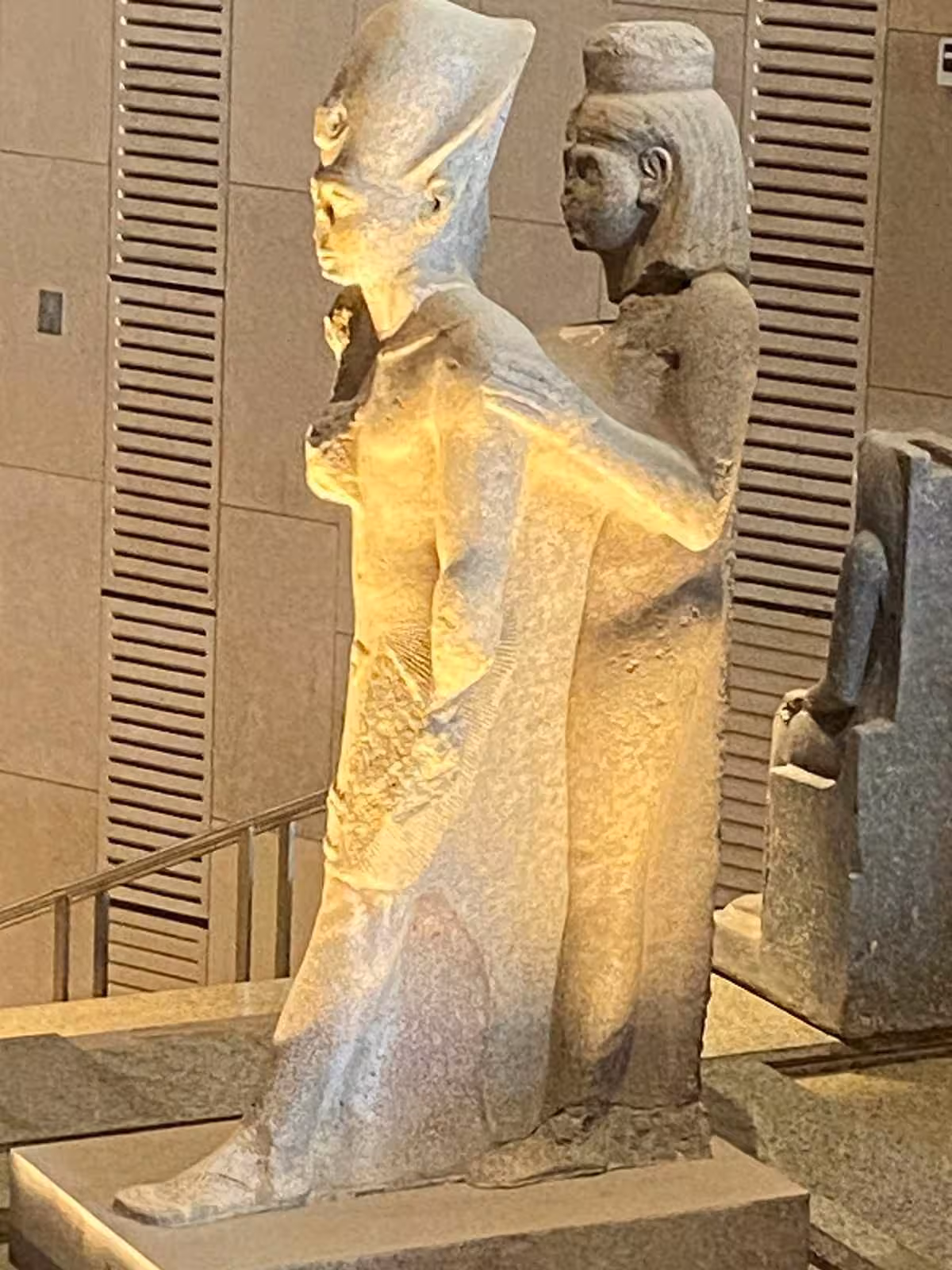 Ancient Egyptian stone statues in the Grand Egyptian Museum gallery on a full-day Giza Pyramids tour with lunch