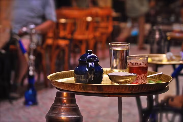 Traditional Egyptian tea and water served on brass tray at Cairo bazaar café during Citadel day tour