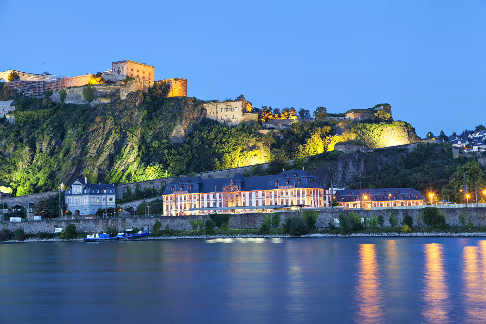 Ehrenbreitstein Fortress lit at dusk above the Rhine in Koblenz, key stop on 1-day walking tour audioguide