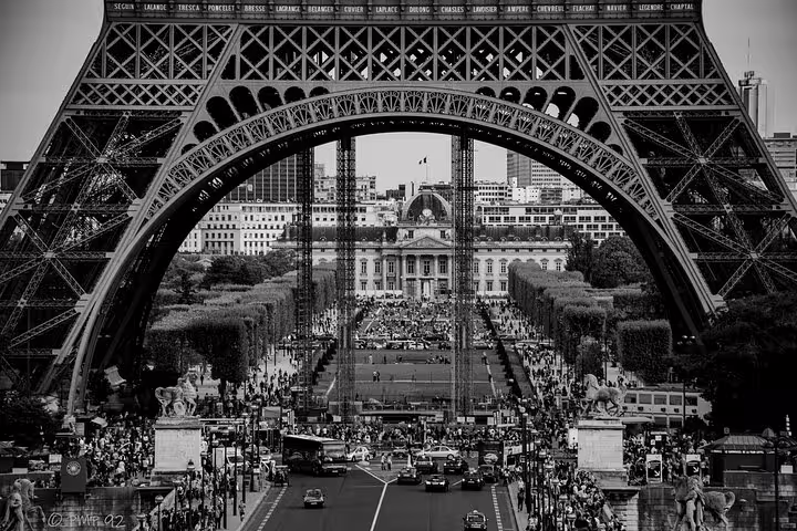 View through Eiffel Tower arch toward Champ de Mars in Paris, black and white