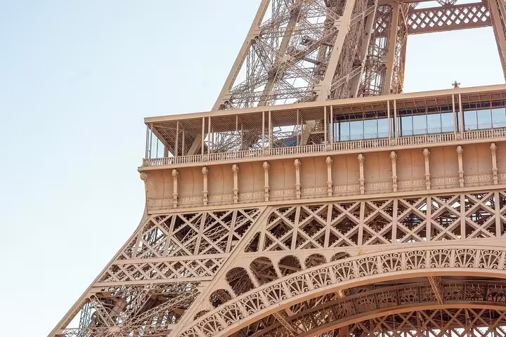 Close-up of Eiffel Tower first floor balcony and ornate iron lattice structure in Paris
