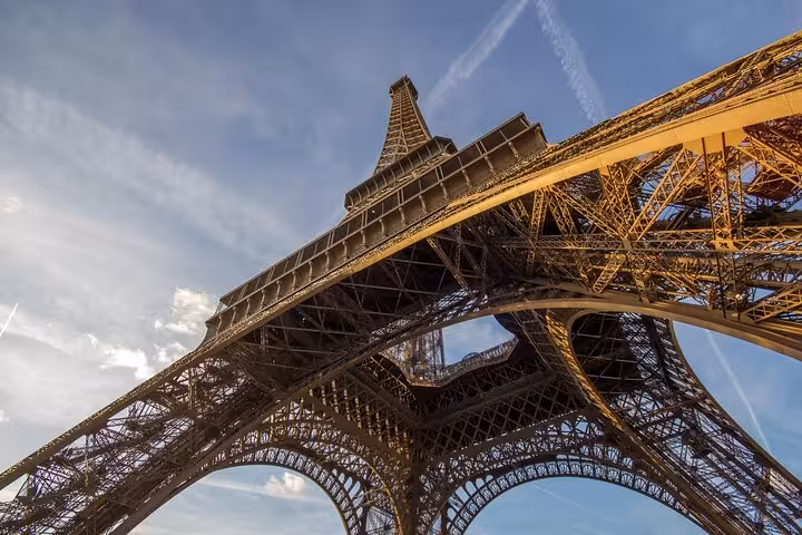 Golden-hour view under the Eiffel Tower, part of a private luxury lunch and Seine cruise tour