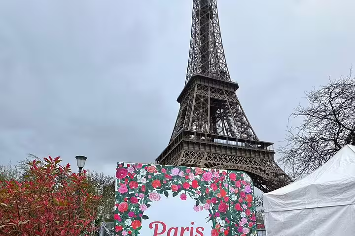 Eiffel Tower rising above a Paris floral sign on a cloudy day in Paris, France