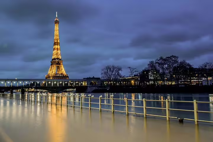 Eiffel Tower illuminated at night reflected on the Seine River in Paris