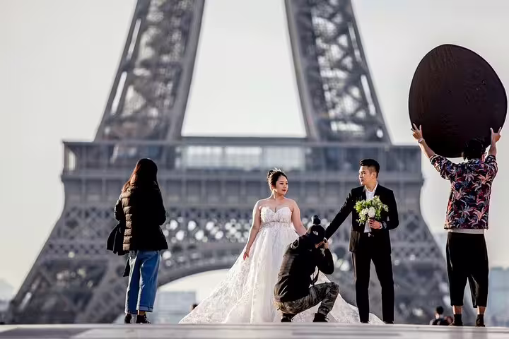 Wedding couple posing for photos in front of the Eiffel Tower in Paris