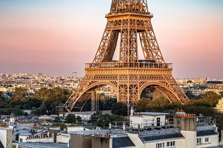 Eiffel Tower at sunset with Paris cityscape and rooftops in the background