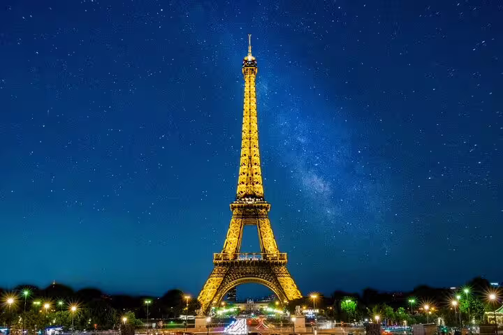Eiffel Tower illuminated in golden light against a starry blue night sky in Paris