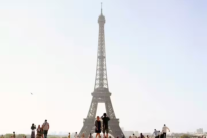 Tourists gathered at the Trocadero with the Eiffel Tower standing tall in Paris on a sunny day