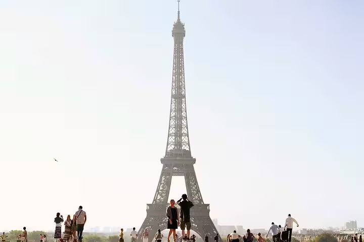 Tourists gathered at the Trocadero with the Eiffel Tower rising against a bright Paris sky