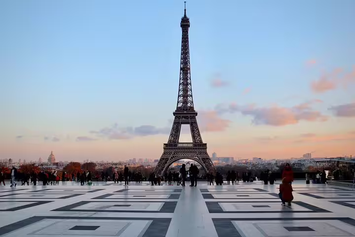Eiffel Tower at sunset viewed from Trocadéro plaza with tourists in Paris