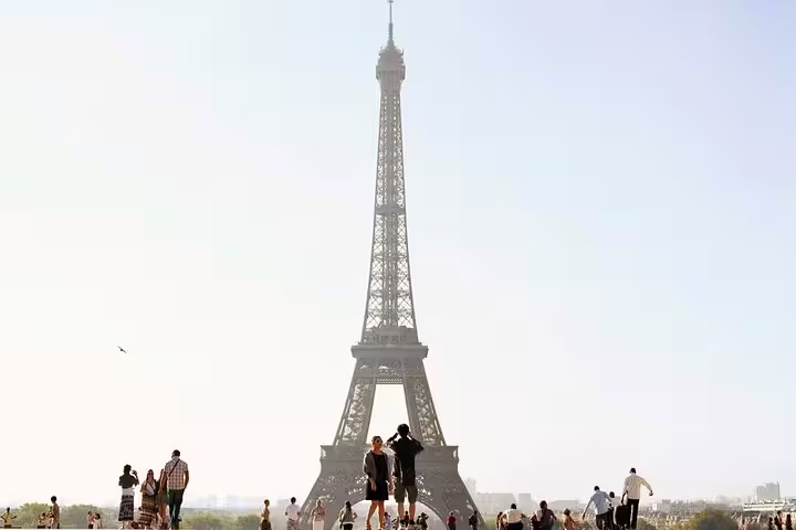 Tourists gathering at Trocadéro plaza with the Eiffel Tower towering in the background on a sunny day in Paris