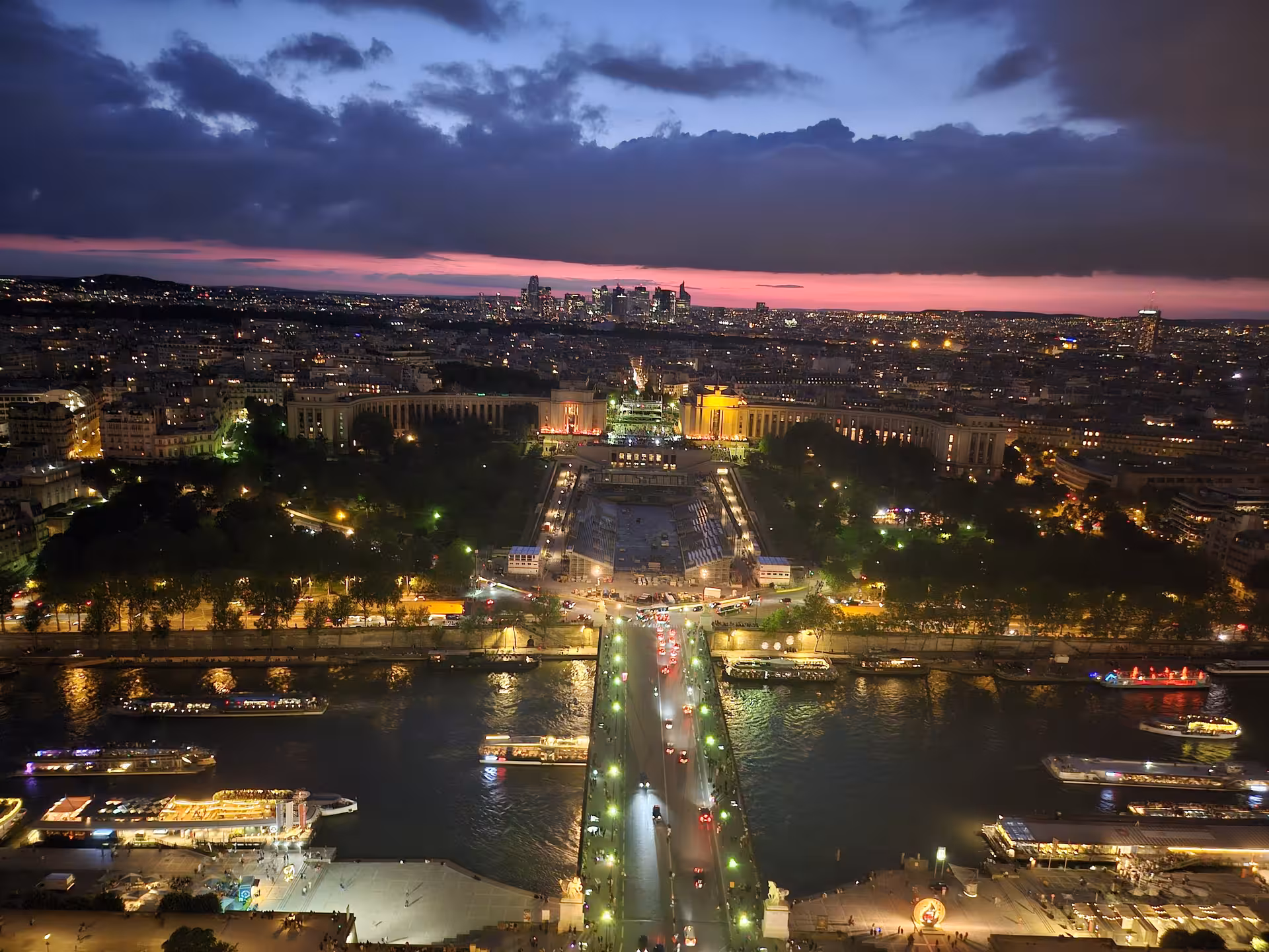Aerial night view of Paris from Eiffel Tower second floor, Seine River and Trocadéro lit up at sunset