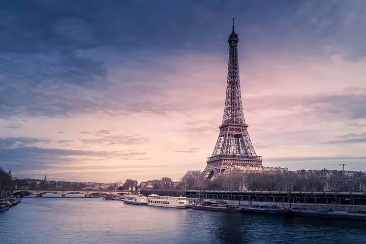 Eiffel Tower and Seine River at dusk, Paris city skyline with boats and bridge