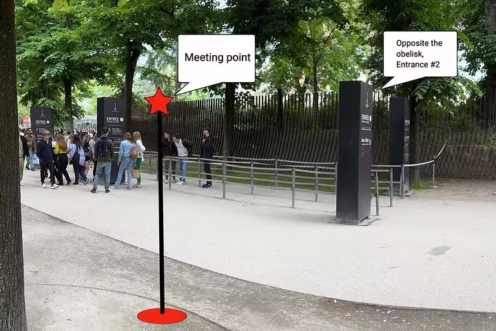 Meeting point marker at Eiffel Tower Entrance 2, opposite the obelisk, with visitors queuing nearby