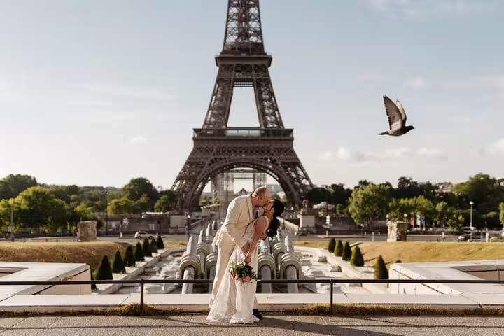 Couple kissing in wedding attire at Trocadero with Eiffel Tower backdrop in Paris