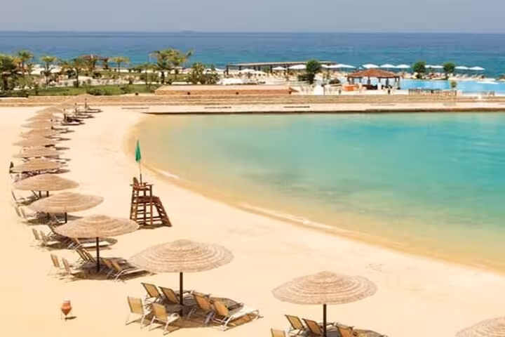 Sandy El Ain El Sokhna beach with umbrellas and calm Red Sea lagoon, ideal day tour from Cairo for swimming