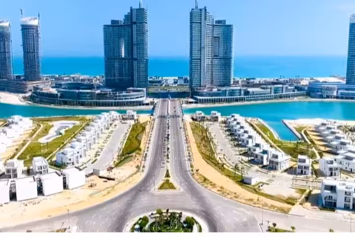 Aerial view of El Alamein New City waterfront with modern skyscrapers, villas, and blue Mediterranean Sea