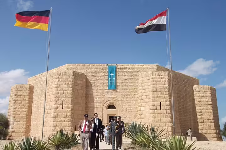 El Alamein War Cemetery entrance with Egyptian and German flags, visited on El-Alamein day tour from Cairo