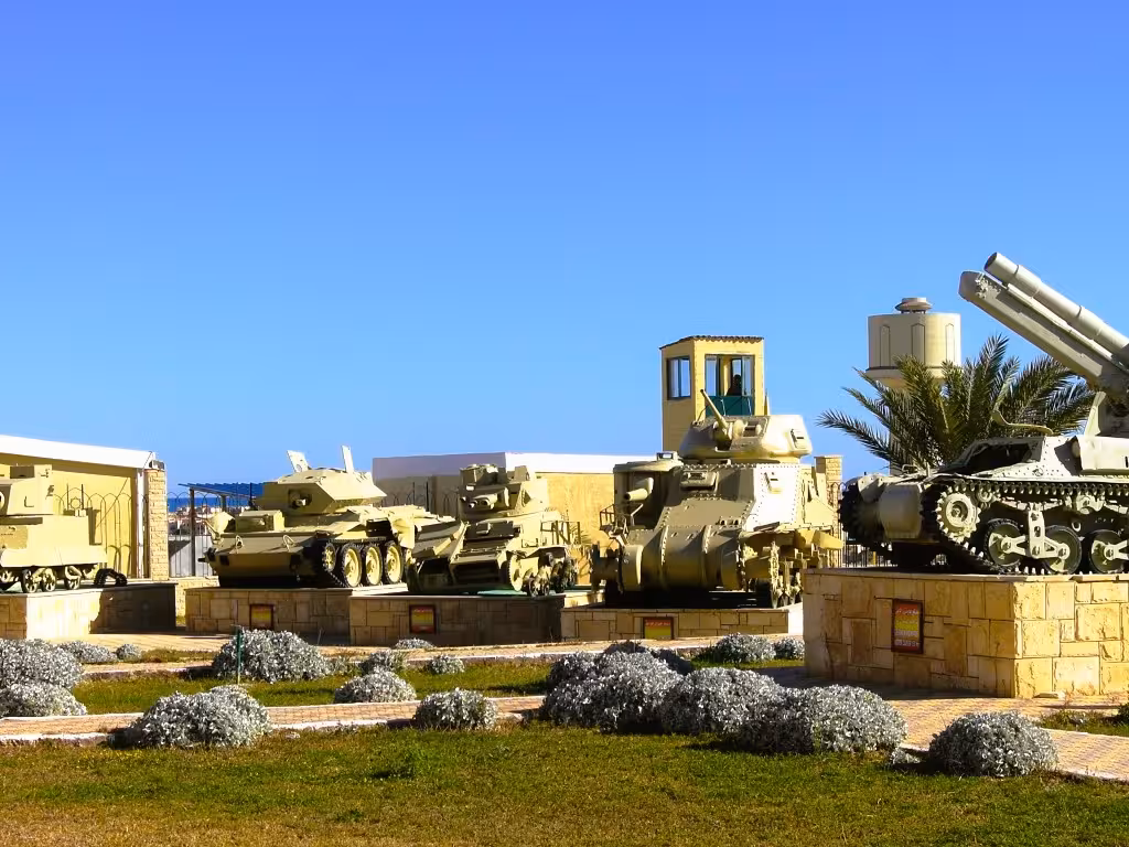 WWII military tanks and artillery on display at El Alamein War Museum, Egypt, under clear blue sky