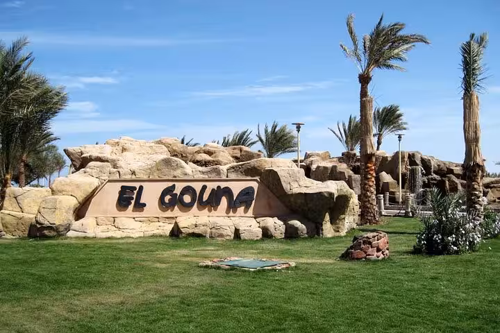 El Gouna entrance sign with palm trees and rocks, stop on private half-day city tour and lagoon cruise