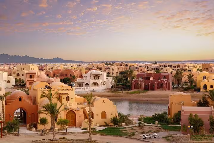 Sunset view of El Gouna lagoon and colorful Nubian-style villas on a private half-day city tour and cruise