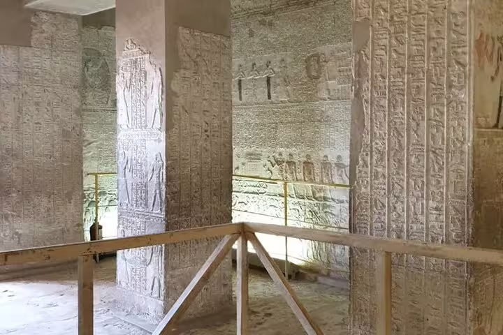 Inside an ancient tomb temple in El Minya with carved hieroglyphs, visited on a private day tour from Cairo