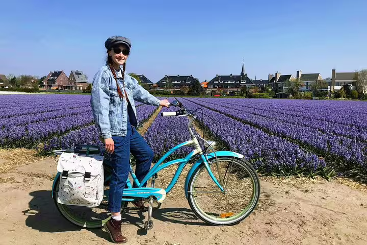 Guest with electric bike beside purple tulip fields on Your Own Holland spring e-bike tour near Lisse