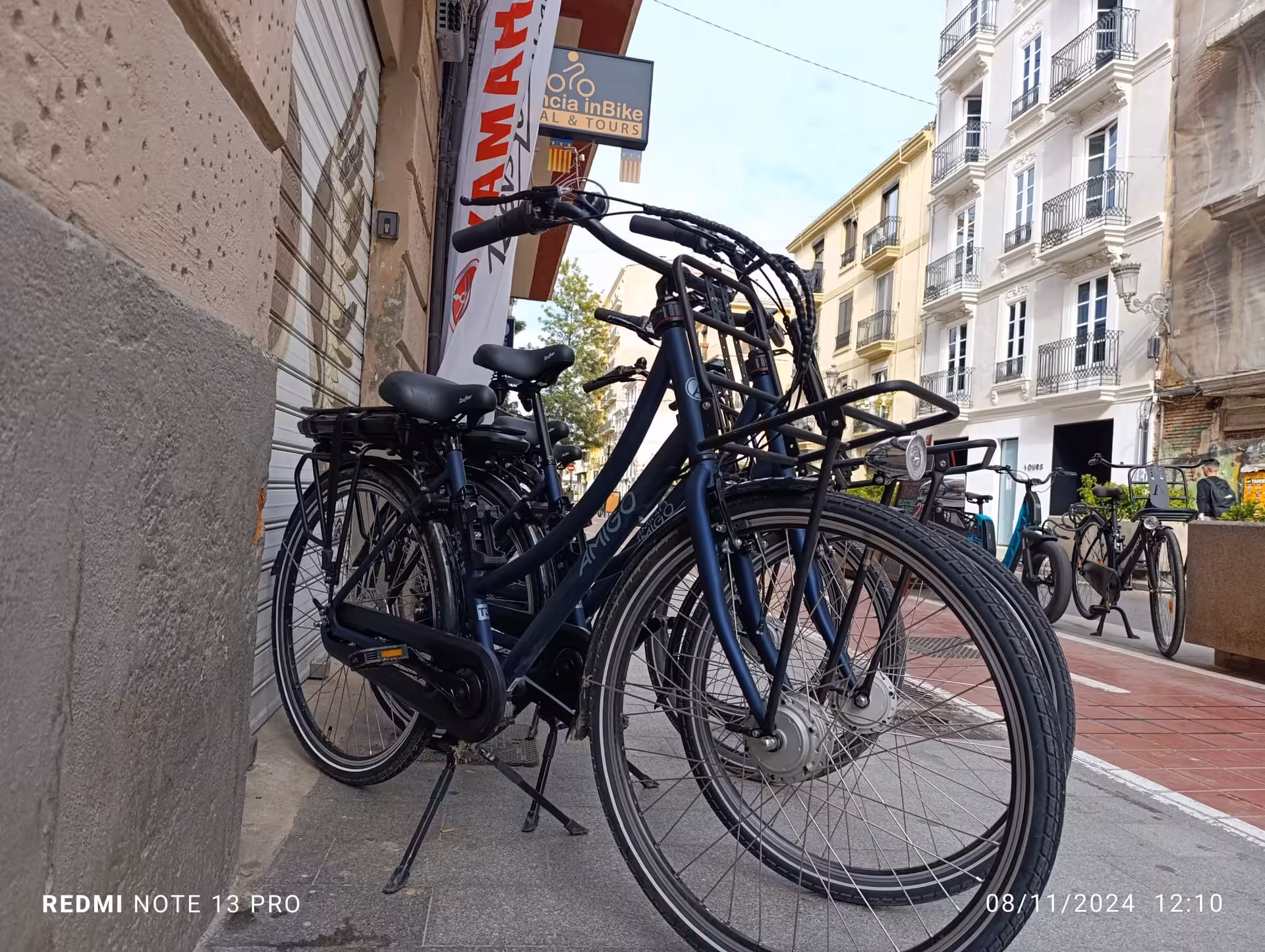 Fleet of electric city bikes parked outside Valencia e-bike rental shop, ready for self-guided touring