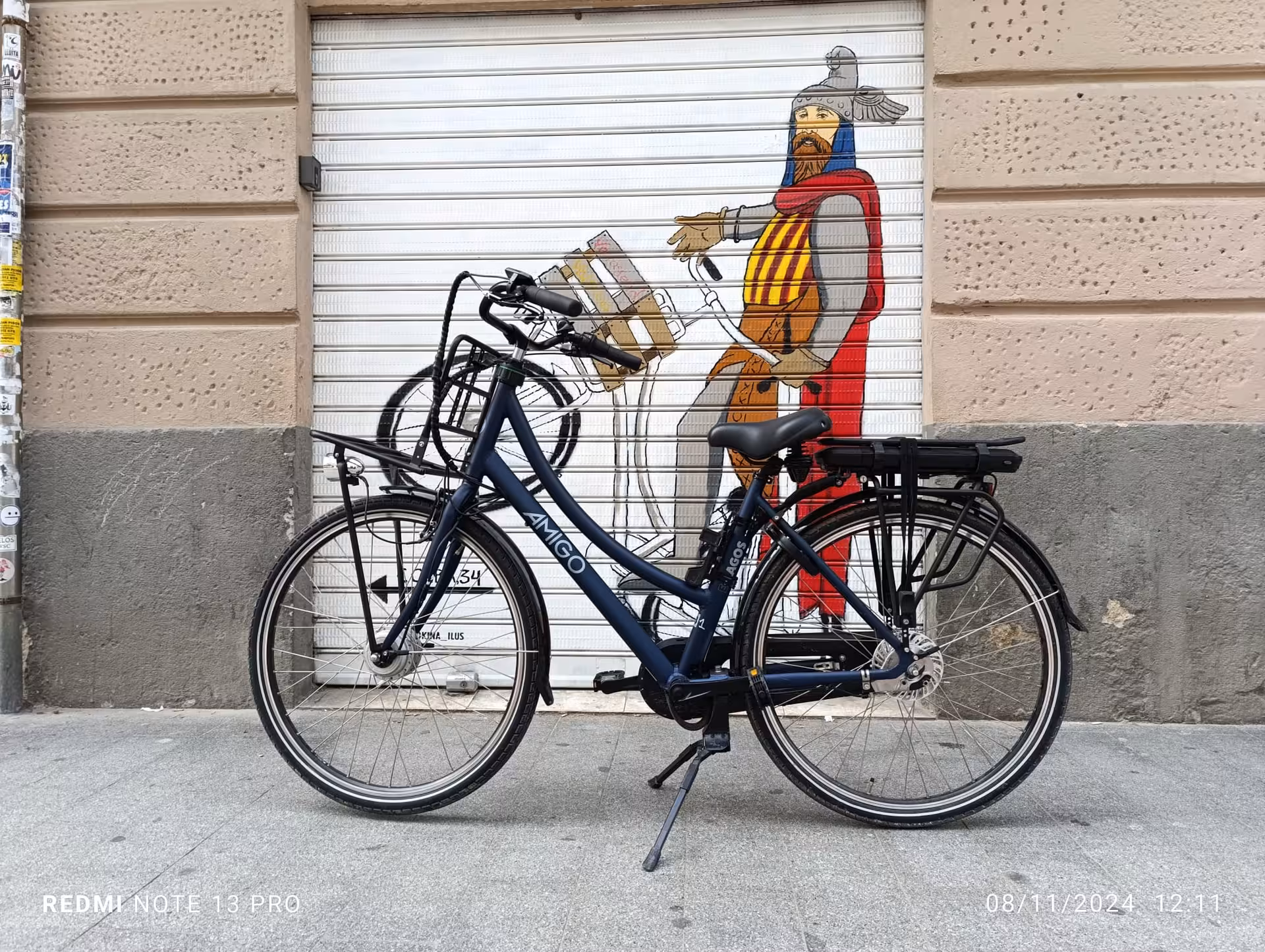 Electric bike rental in Valencia with step-through e-bike parked by street art mural, ideal for city rides