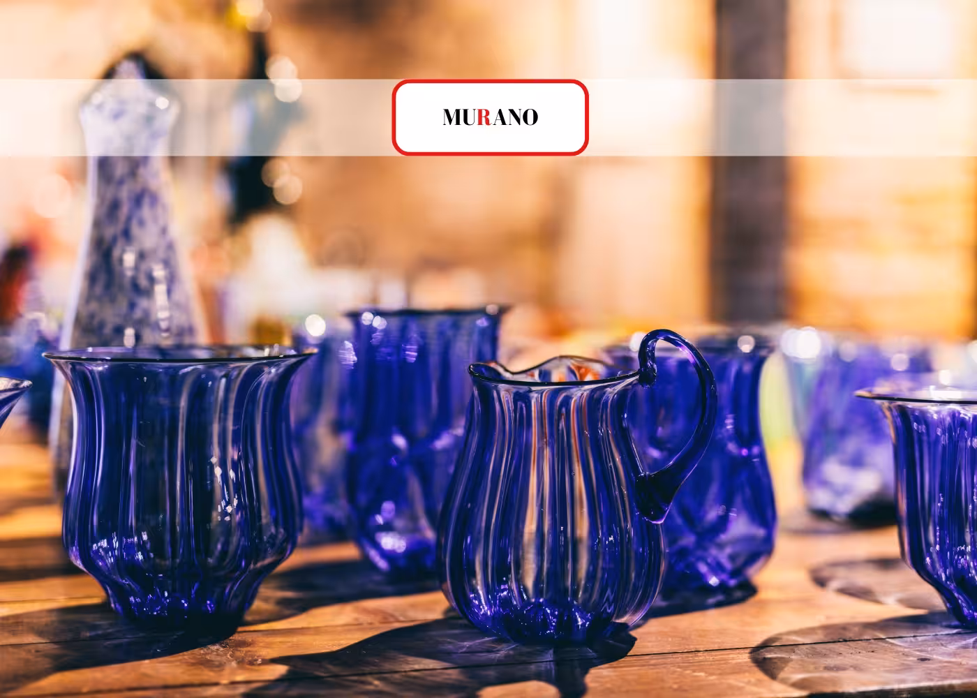 Elegant blue Murano glassware displayed on a wooden table, highlighting the island's renowned glass artistry.