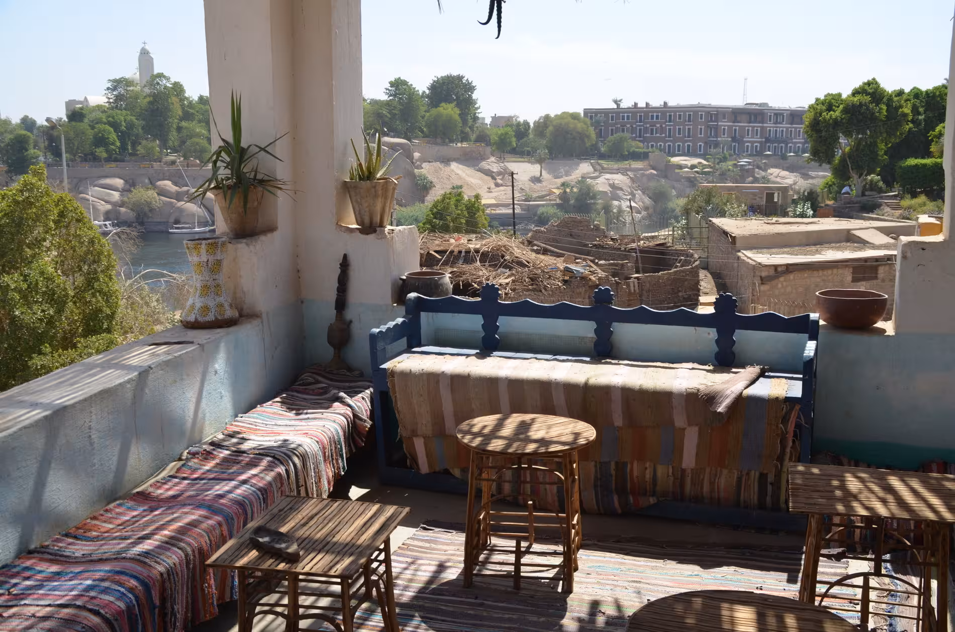 Rooftop terrace with colorful benches overlooking the Nile River and Elephantine Island in Aswan