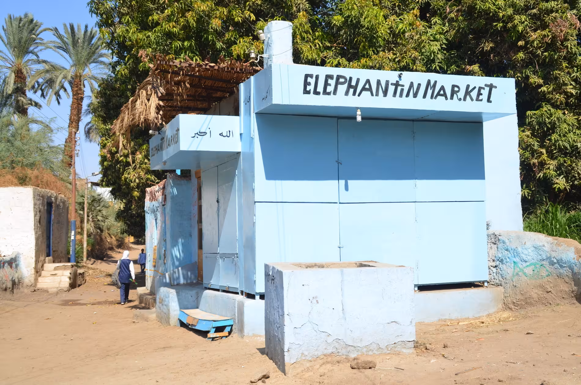 Elephantine Market entrance building painted light blue with Arabic text, Aswan Egypt